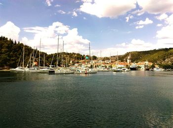 Sailboats moored in sea against sky