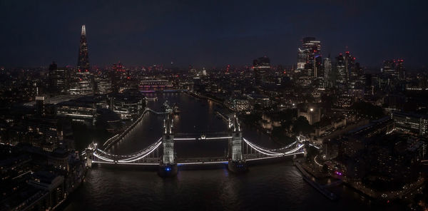 Aerial view to the illuminated tower bridge and skyline of london, uk