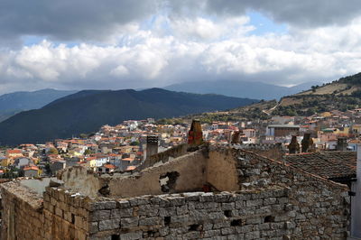 Houses in town against cloudy sky