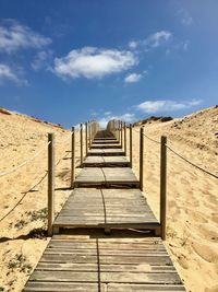 Wooden boardwalk on the beach against sky