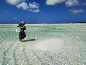 Full length of man on shore at beach against sky