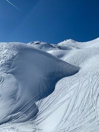 Scenic view of snowcapped mountains against clear blue sky