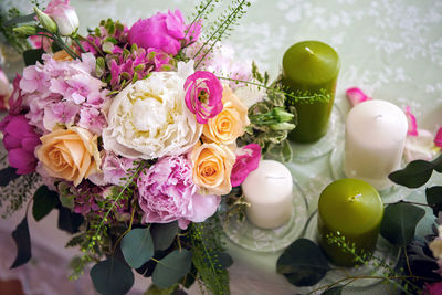 Wedding table setting with green candle and flowers