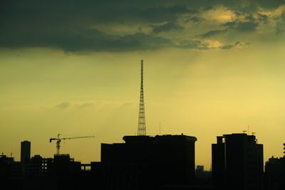 Silhouette of city against cloudy sky