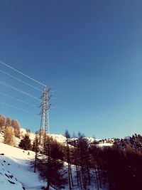 Low angle view of ski lift against clear sky