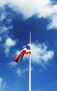 Low angle view of flag against blue sky