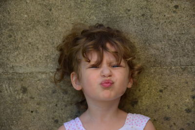 Portrait of girl against wall