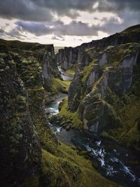 Scenic view of river by mountains against sky