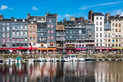 Boats moored on river against buildings in city