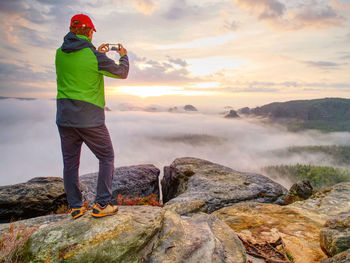 Hiker travel alone, take and share photos from outdoor trips. fall nature within misty morning. 