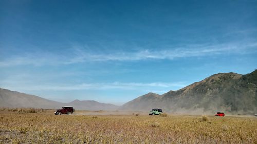 Places of interest three jeeps crossing the valley amongst mountains range in east java indonesia