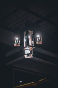 Low angle view of illuminated pendant lights hanging from ceiling