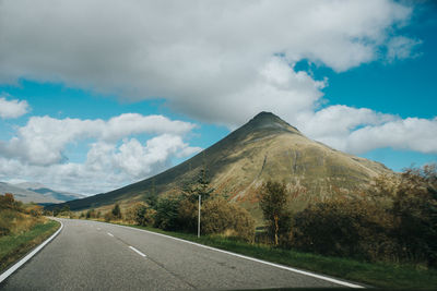 Empty road along landscape against sky