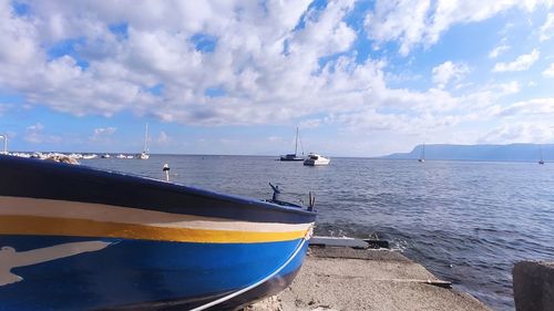 Sailboats moored on sea against sky