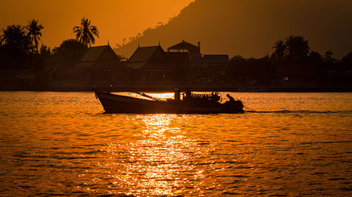 Silhouette boat in sea during sunset