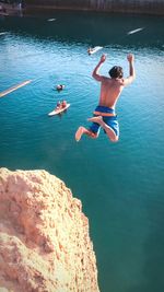 High angle view of woman jumping in sea