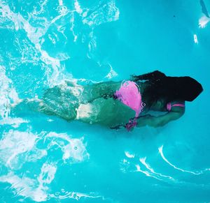 Low section of man swimming in water