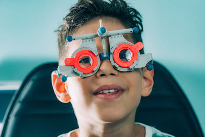 Close-up portrait of boy with eye test equipment