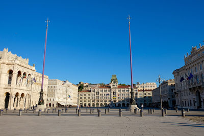 Historic buildings at town square against clear blue sky