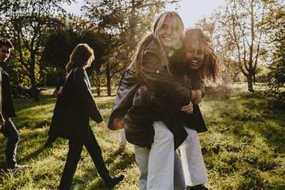 Women standing on field against trees