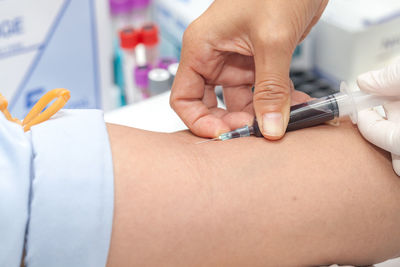 Cropped image of doctor injecting patient