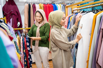 Smiling female friends shopping clothes