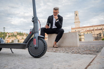 Businessman using mobile phone while sitting outdoors