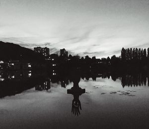 Silhouette woman standing by trees against sky in city