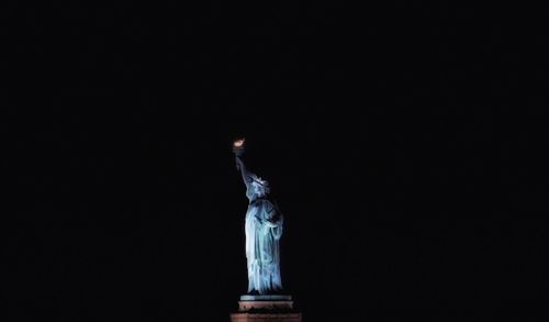 Close-up of illuminated candle in darkroom