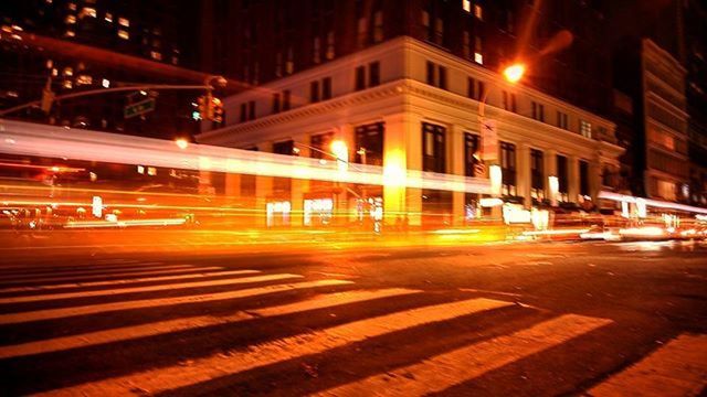 illuminated, night, building exterior, architecture, built structure, city, street, street light, city street, lighting equipment, road, city life, transportation, light - natural phenomenon, incidental people, motion, light trail, long exposure, outdoors, car