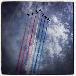 Low angle view of airshow against sky