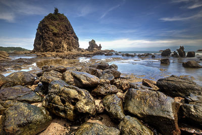 Rock formations in sea against sky