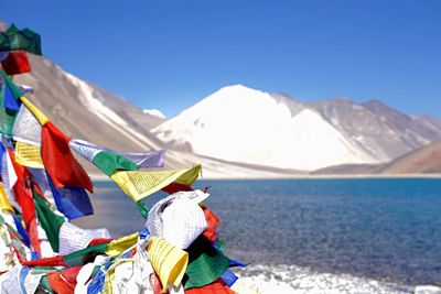 Multi colored flags on mountain against clear sky