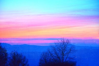 Silhouette bare trees on landscape against romantic sky at sunset