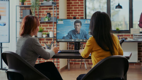 Rear view of businesswomen during teleconference