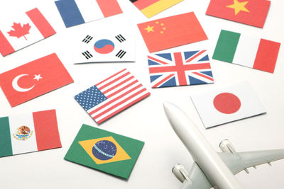 Close-up of various flags by toy airplane against white background