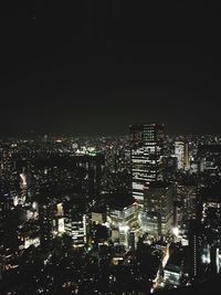 Illuminated cityscape against sky at night