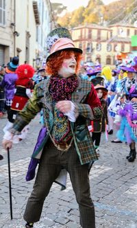 Clown standing on footpath in city