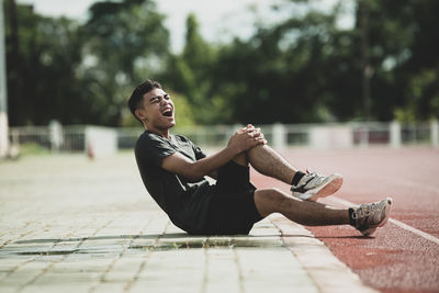 Man sitting on footpath