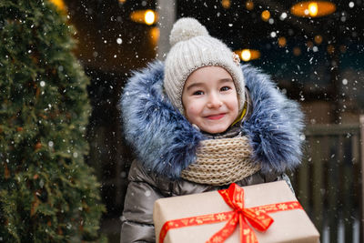 Portrait of smiling young woman holding gift