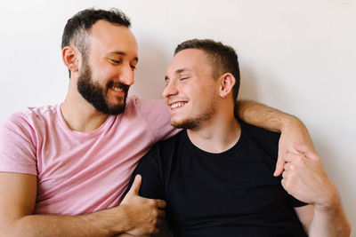 Gay couple laughing at home.