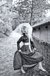 Woman wearing mask on field against trees