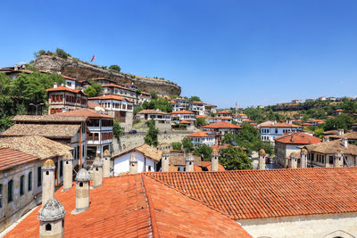 Houses in town against clear blue sky