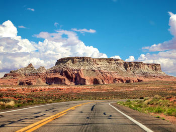 Road by rock formations against sky