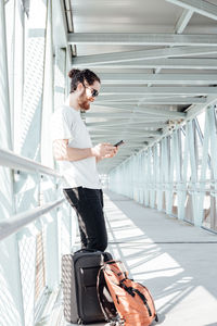 Side view of man using smart phone at bridge