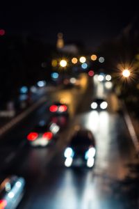 Defocused image of illuminated city against sky at night