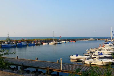 Boats in sea against clear sky