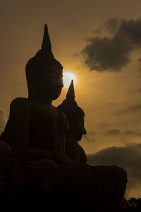 Buddha statue against sky during sunset