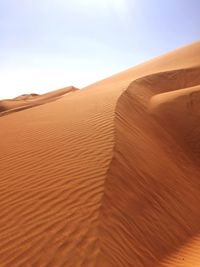 Sand dunes in desert against sky