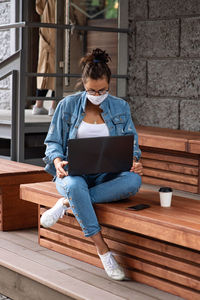 Full length of woman using laptop outdoors